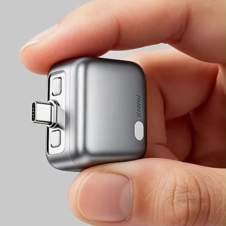 The adapter held between two fingertips, showing its polished squircle body and USB-C plug.